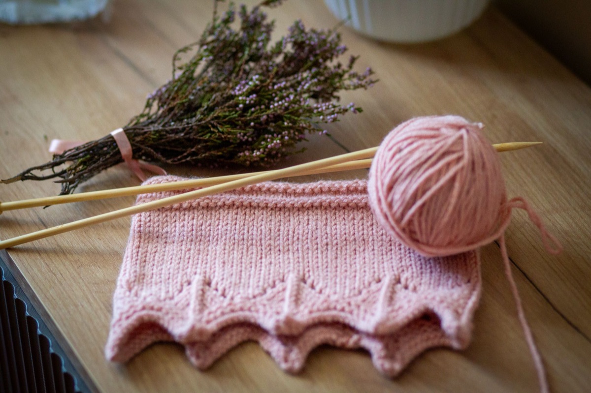 Knitting needles and yarn on wooden table
