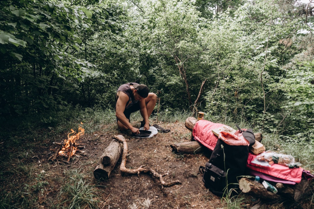Minimalist camping gear setup in a forest clearing