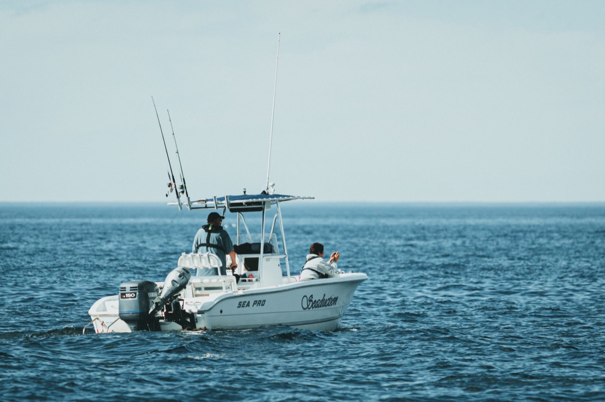 fishing boat with angler casting line