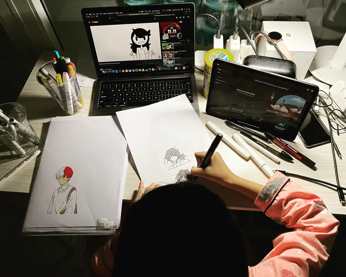 아니메 캐릭터를 그리는 예술가, 데스크톱에 툴리지 강의를 보며 주변에 예술 도구들이 놓여 있습니다.